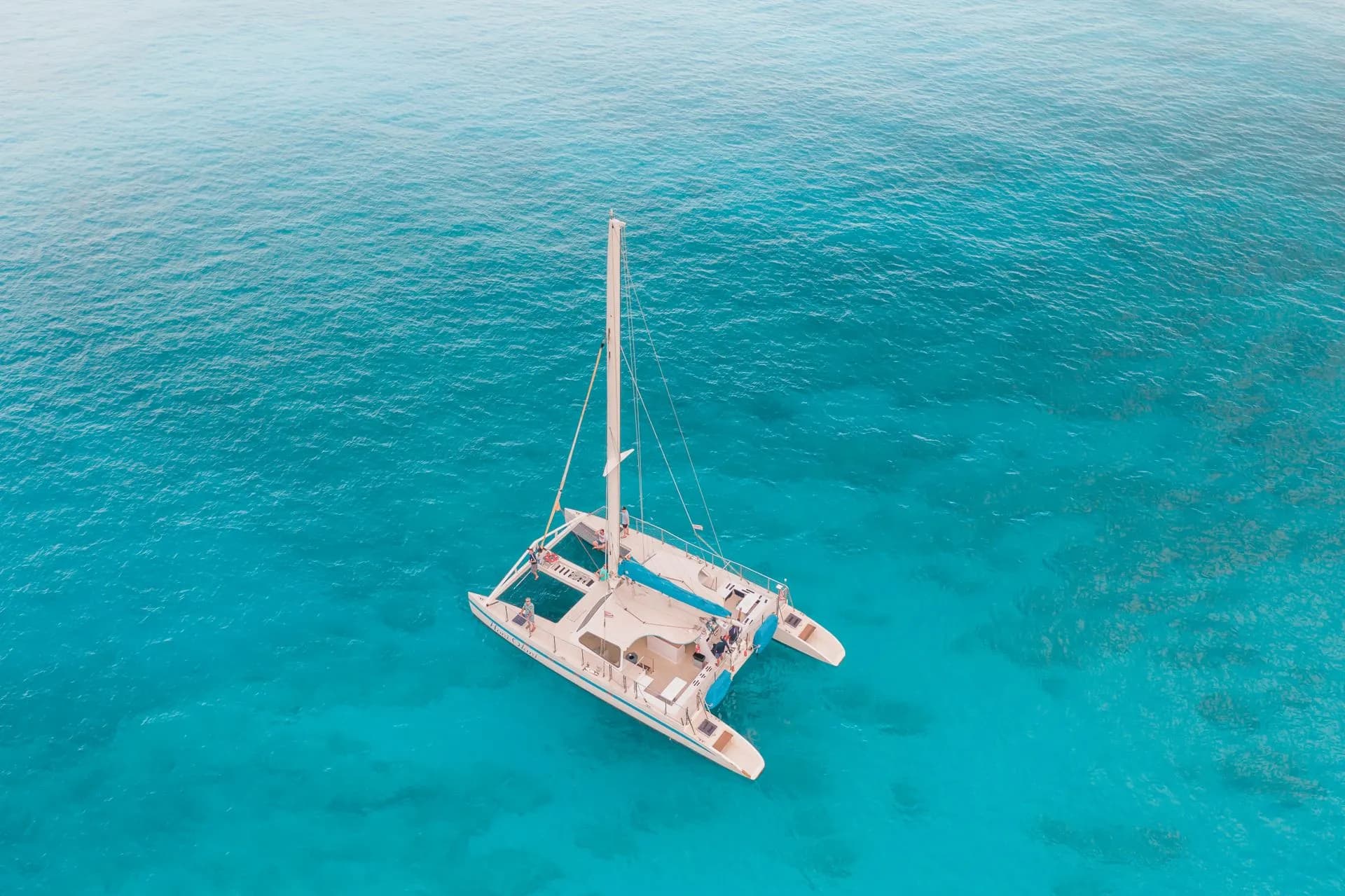 Sailing catamaran anchored over turquoise shallow water off Bavaro Beach in Punta Cana